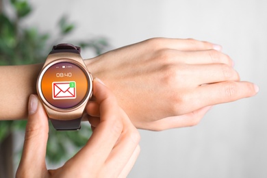 Woman checking mail application in smart watch, closeup