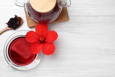 Delicious hibiscus tea and flowers on white wooden table, flat lay. Space for text