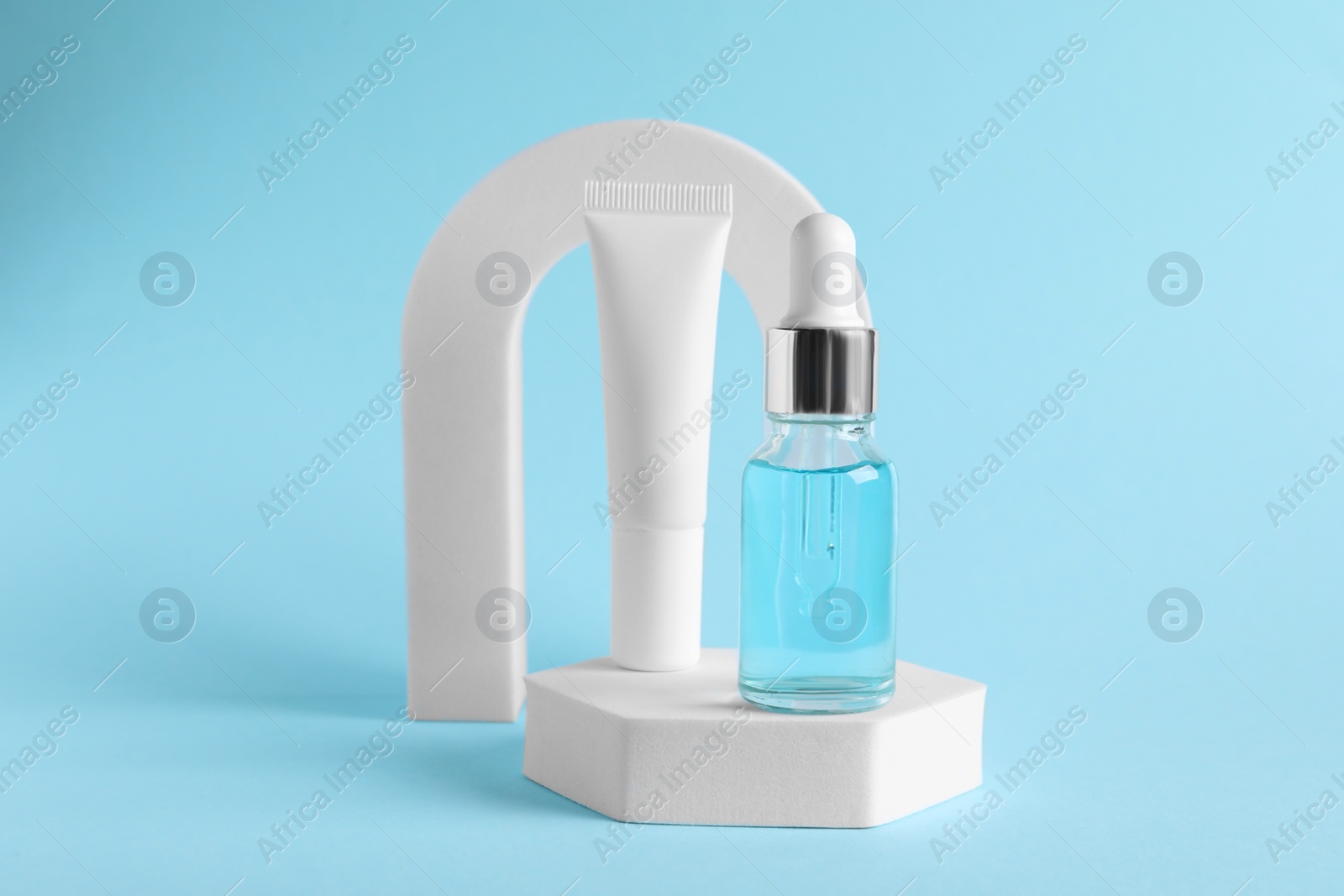 Photo of Stylish presentation of cosmetic serum on light blue background