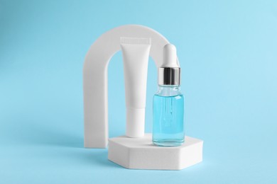Stylish presentation of cosmetic serum on light blue background
