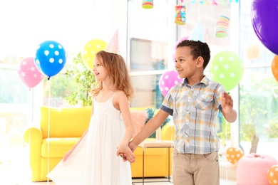 Photo of Cute little children at birthday party indoors