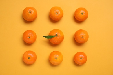 Photo of Fresh ripe tangerines on orange background, flat lay
