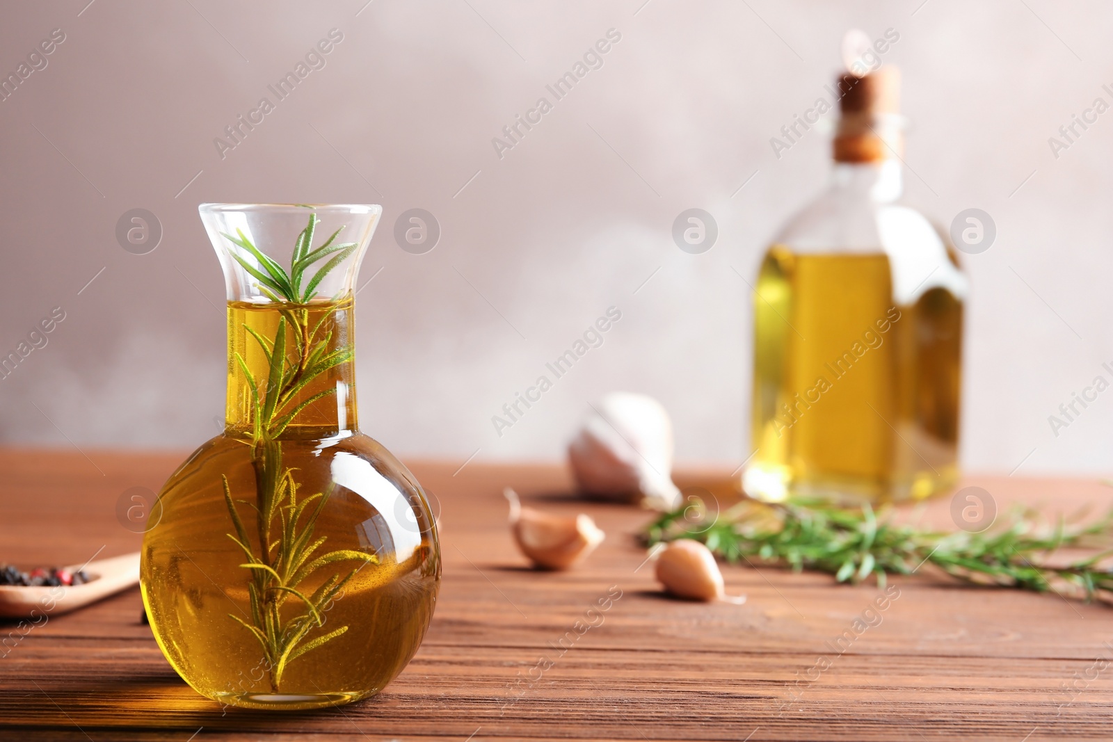 Photo of Composition with bottle of rosemary oil on wooden table