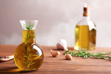 Composition with bottle of rosemary oil on wooden table