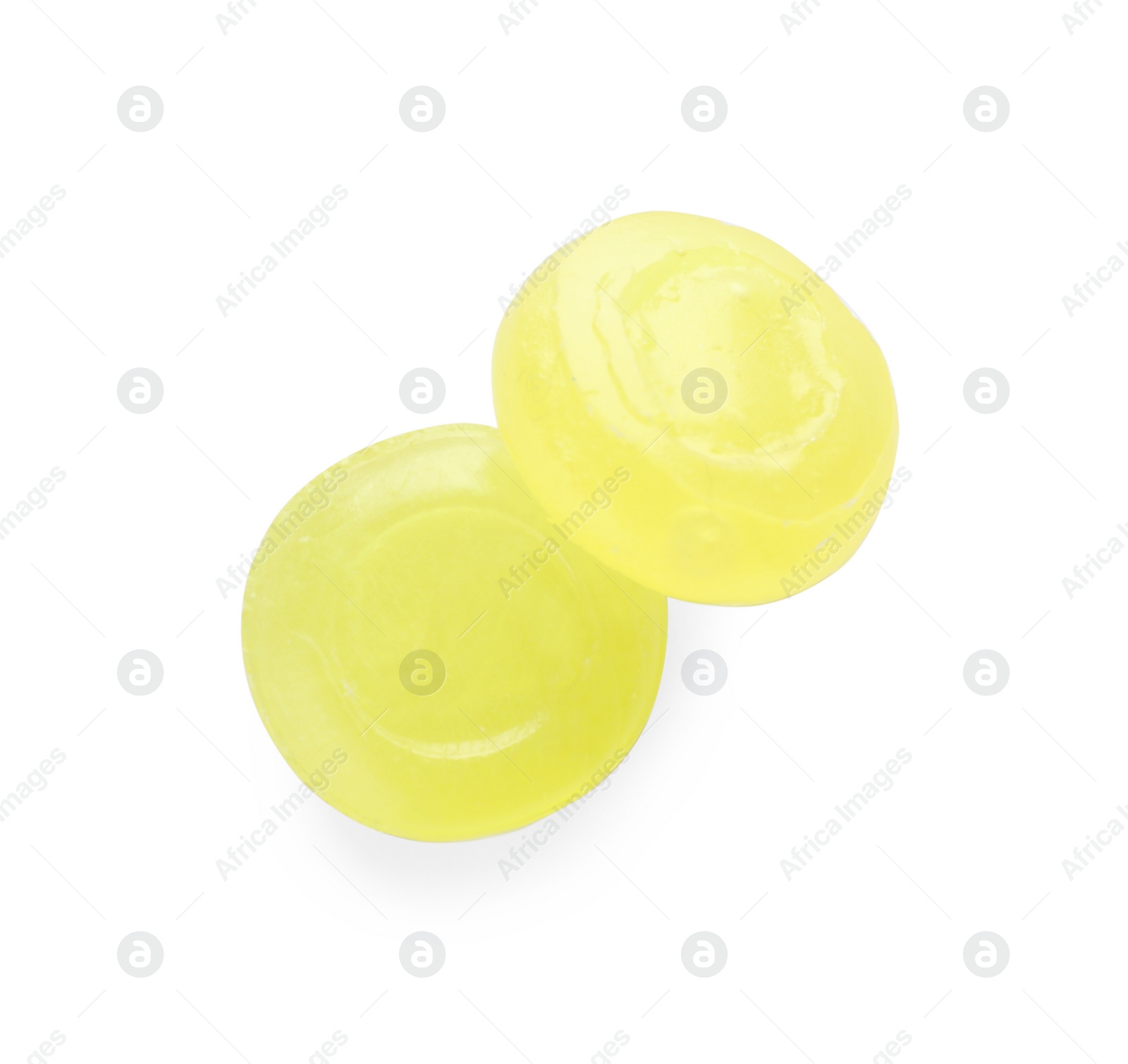 Photo of Two yellow cough drops on white background, top view
