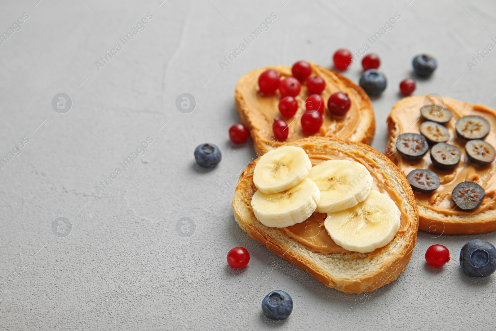 Photo of Slices of bread with different toppings on grey table