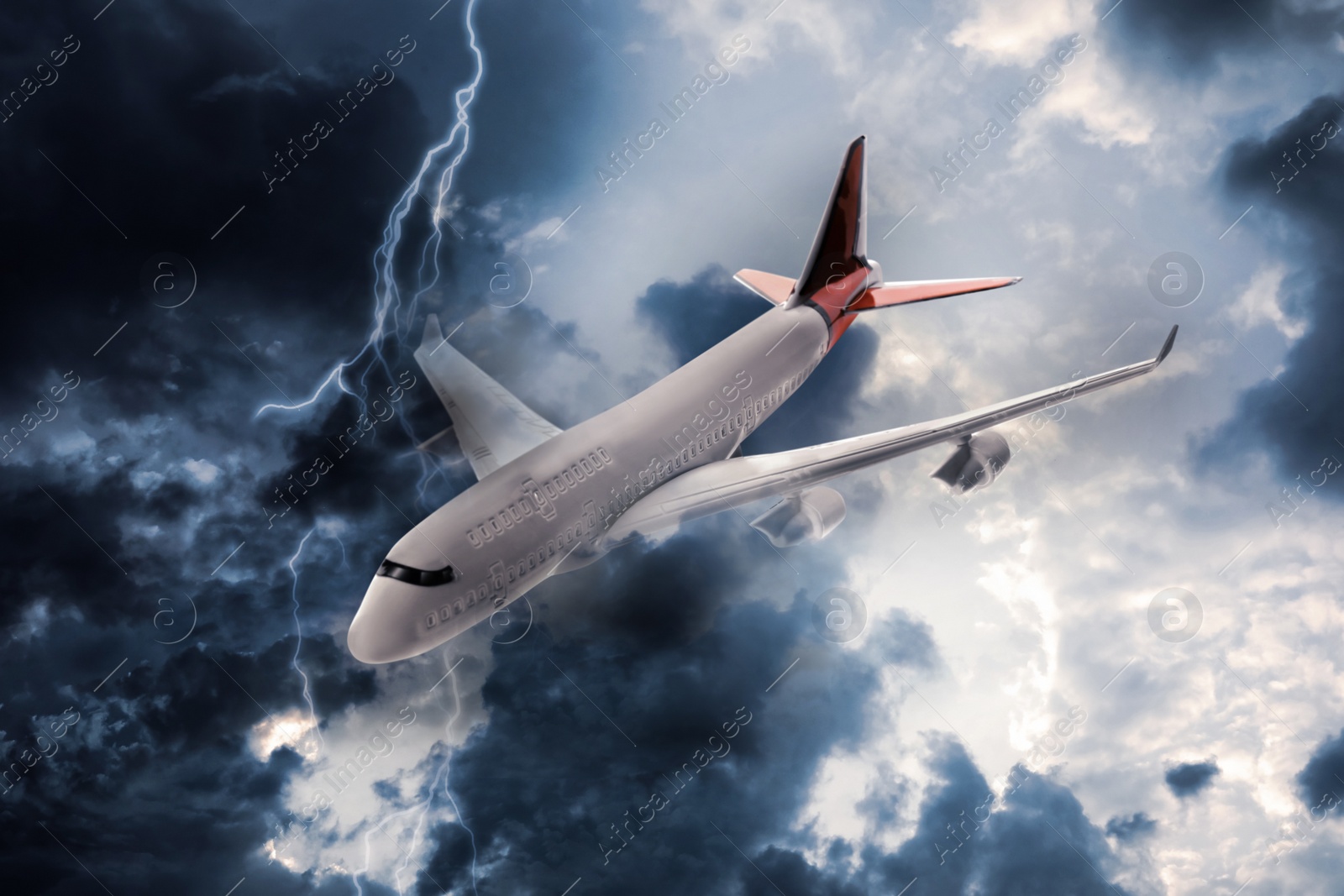 Image of Airplane flying in cloudy sky during thunderstorm