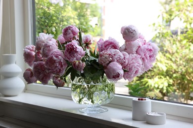 Photo of Beautiful pink peonies in vase on window sill. Interior design