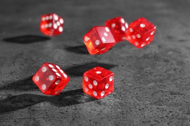 Photo of Many red game dices falling on grey textured table