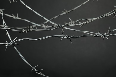 Metal barbed wire on dark grey background