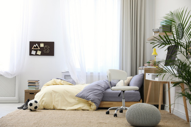 Photo of Stylish teenager's room interior with comfortable bed and workplace