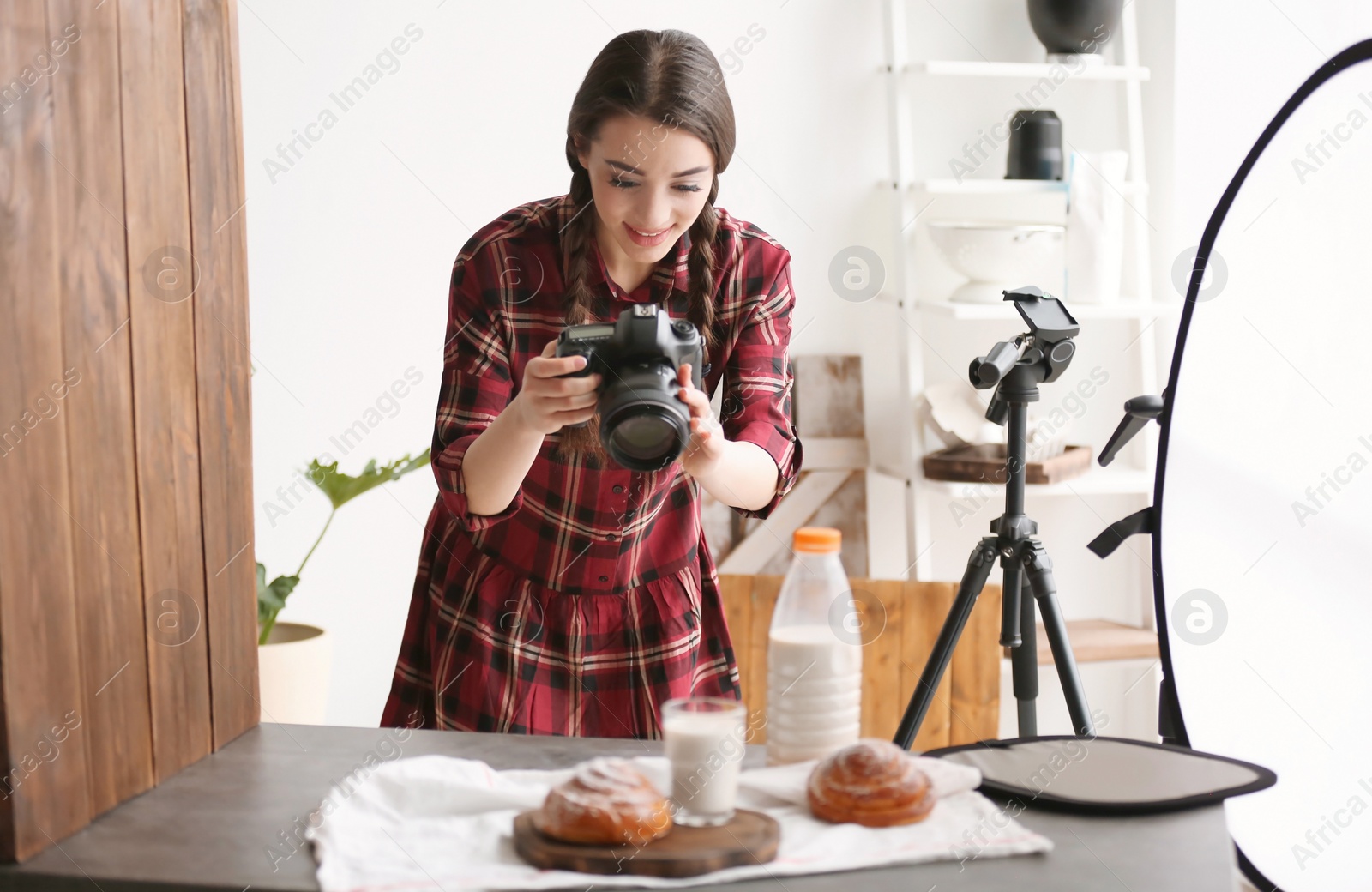 Photo of Young woman with professional camera taking food photo in studio