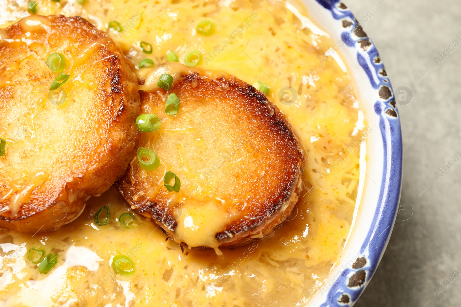 Photo of Tasty homemade french onion soup on table, closeup