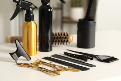 Photo of Hairdresser tools. Different scissors and combs on white table in salon