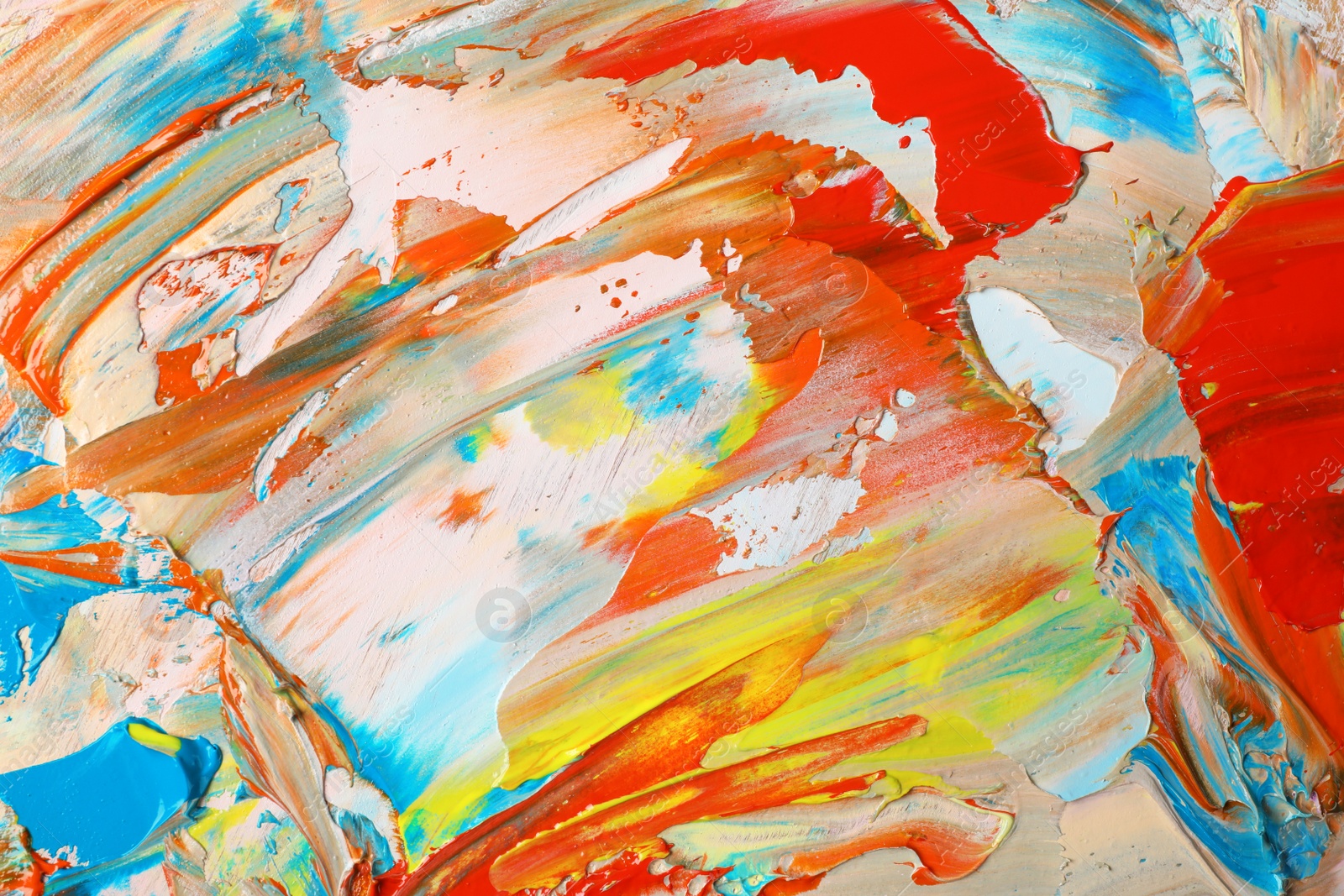 Photo of Closeup view of artist's palette with mixed bright paints as background