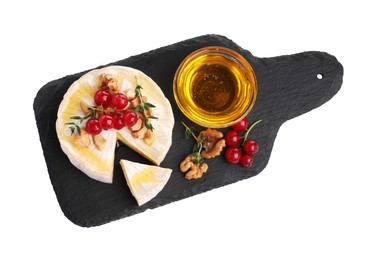 Photo of Brie cheese served with red currants, walnuts and honey isolated on white, top view
