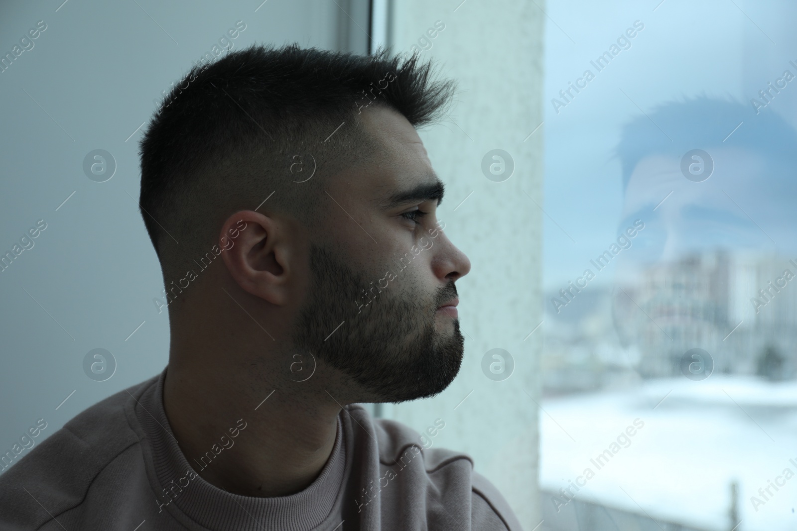 Photo of Sad man looking at window at home