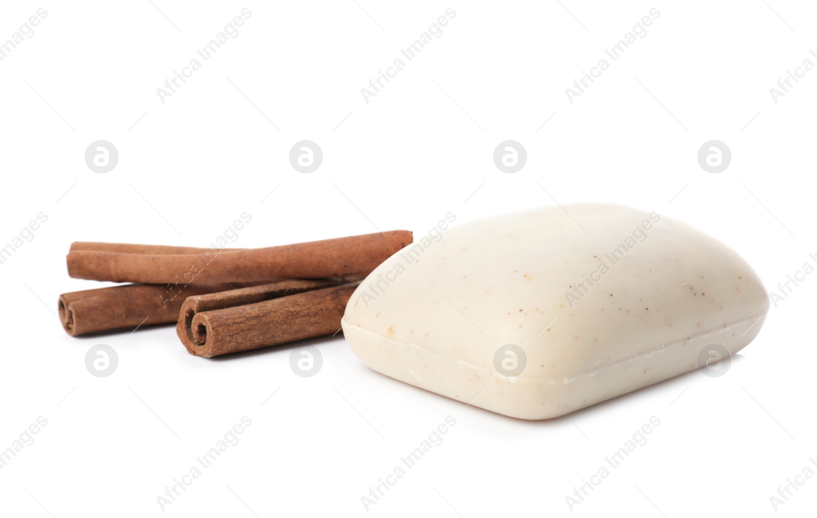 Photo of Soap bar and cinnamon sticks on white background