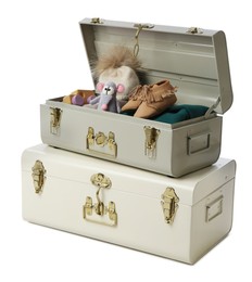 Stylish storage trunks with child's shoes and toys on white background. Interior elements