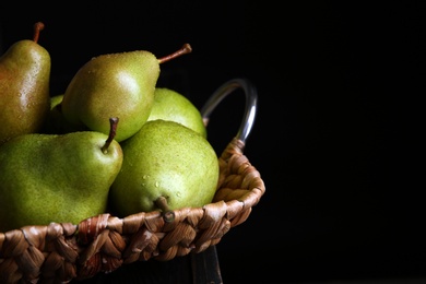 Photo of Tray with ripe pears on table against dark background, closeup. Space for text