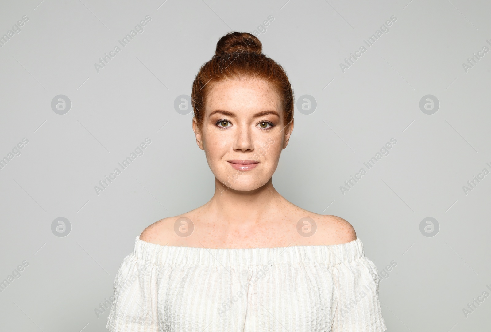 Photo of Portrait of young woman with beautiful face on grey background