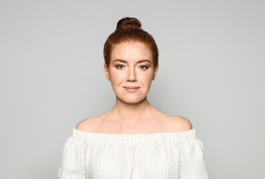 Photo of Portrait of young woman with beautiful face on grey background