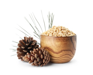 Photo of Bowl with pine nuts and cones on white background