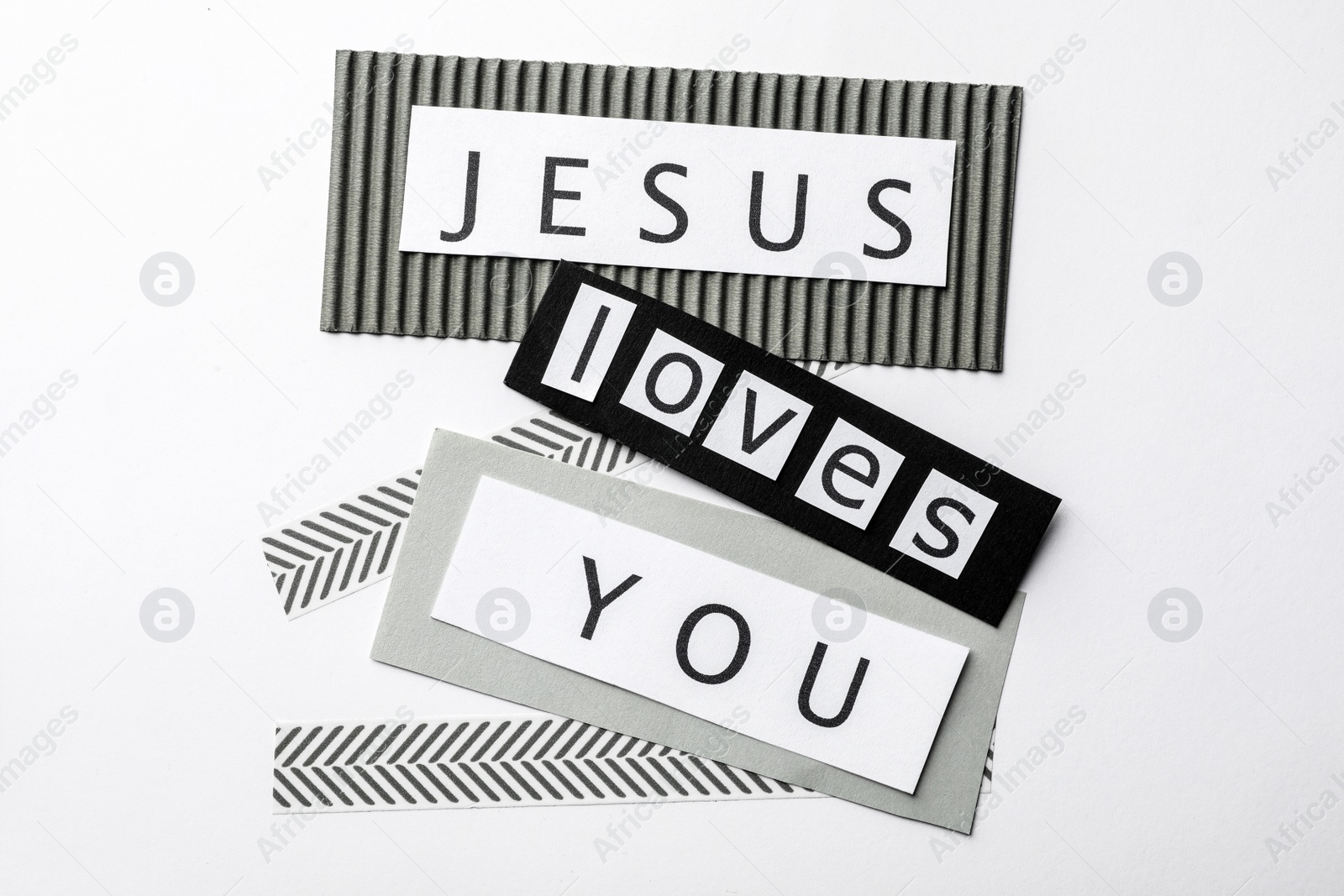 Photo of Printed words JESUS LOVES YOU on white background, top view