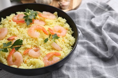 Photo of Delicious risotto with shrimps and parsley in bowl on table, closeup. Space for text