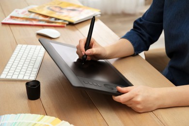 Photo of Professional designer working on graphic tablet at desk, closeup