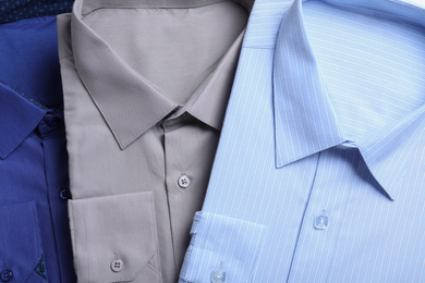 Stylish shirts as background, top view. Dry-cleaning service