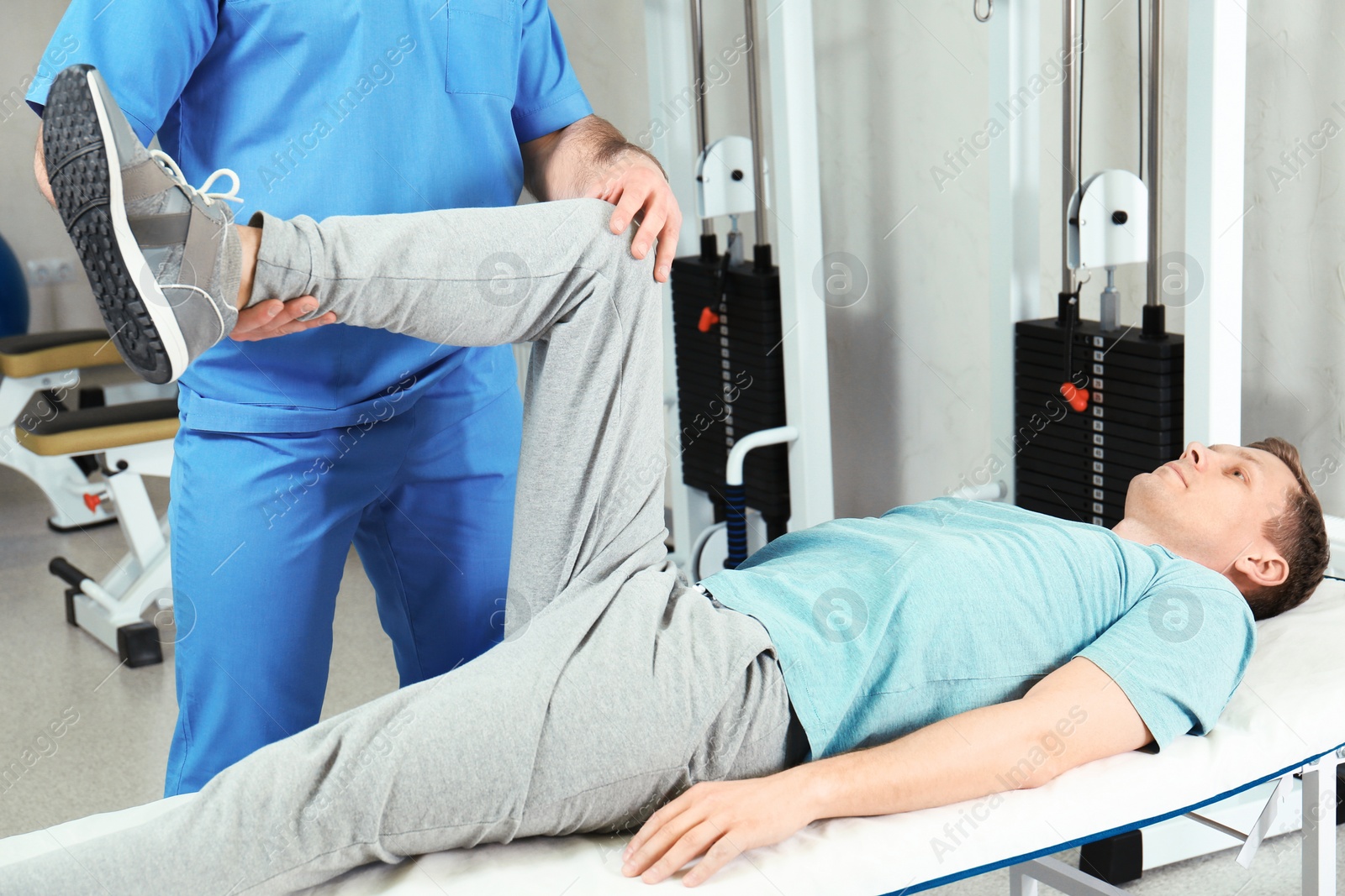 Photo of Physiotherapist working with patient in rehabilitation center