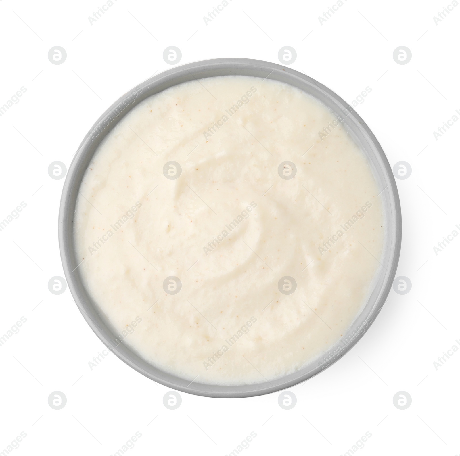 Photo of Delicious semolina pudding in bowl isolated on white, top view