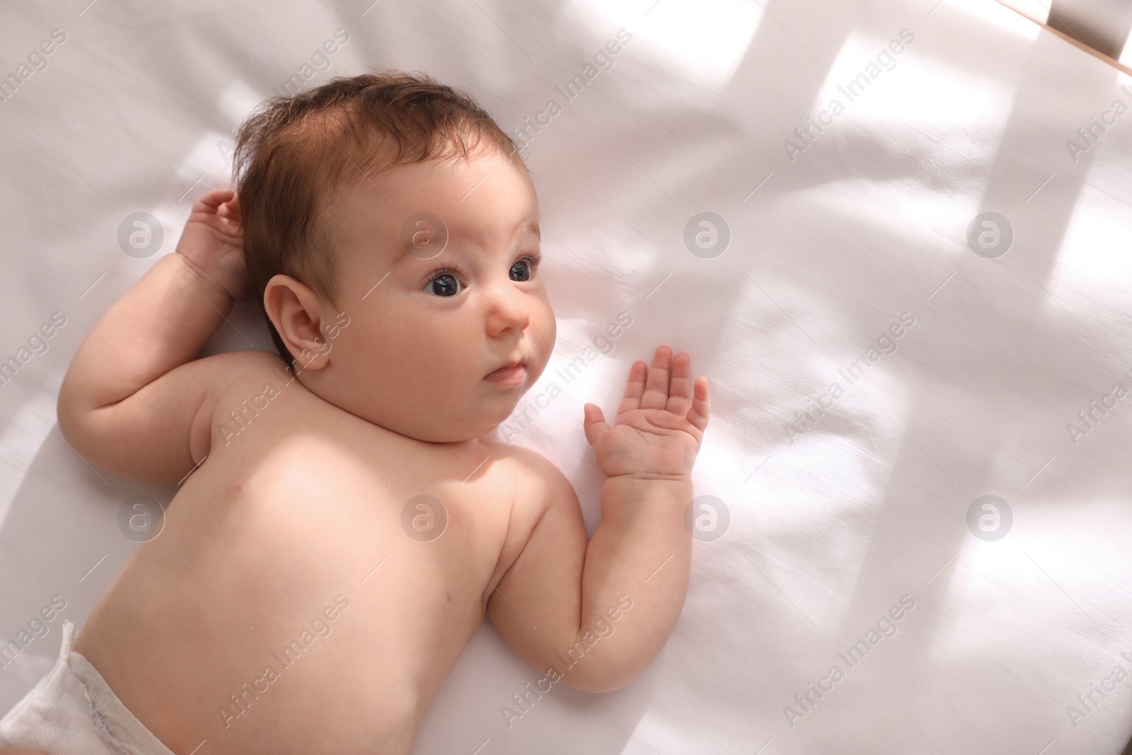 Photo of Cute little baby on bed, top view