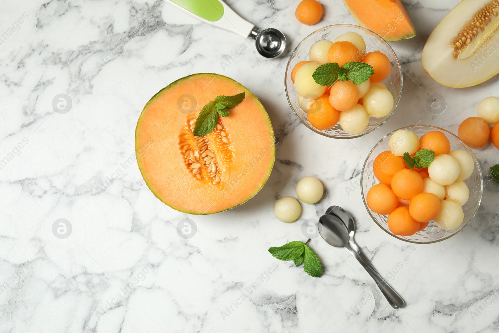 Photo of Flat lay composition with melon balls and mint on white marble table, space for text