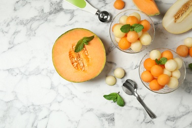 Photo of Flat lay composition with melon balls and mint on white marble table, space for text