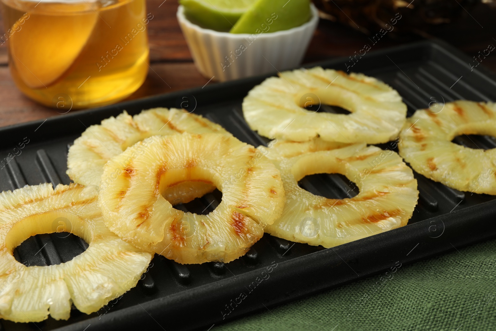 Photo of Tasty grilled pineapple slices on table, closeup