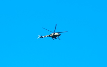 Modern military helicopter flying in blue sky