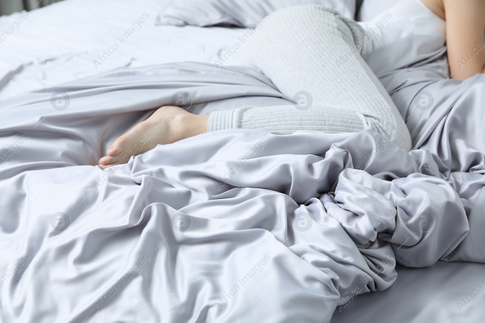 Photo of Young woman sleeping in comfortable bed with silky linens, closeup