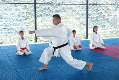 Photo of CHERNOMORKA, UKRAINE - JULY 10, 2020: Karate instructor with little children on training ground