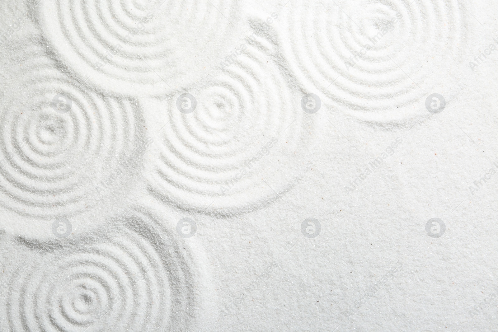 Photo of Zen rock garden. Circle patterns on white sand, top view