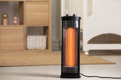 Photo of Modern infrared heater on floor in cozy room. Space for text