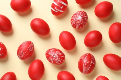 Flat lay composition of red painted Easter eggs on color background