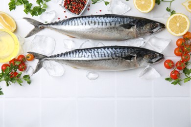 Photo of Raw mackerel, peppercorns and tomatoes on white tiled table, flat lay. Space for text