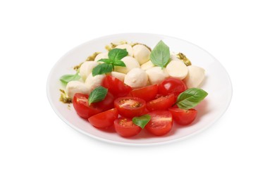 Photo of Plate of tasty Caprese salad with mozzarella, tomatoes, basil and pesto sauce isolated on white