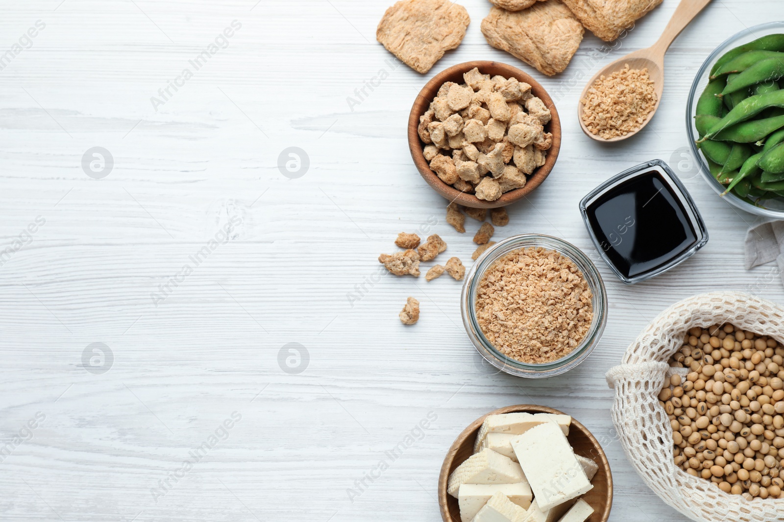 Photo of Different organic soy products on white wooden table, flat lay. Space for text