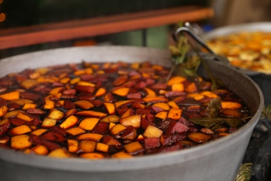 Big pot with mulled wine at Christmas fair stall, closeup