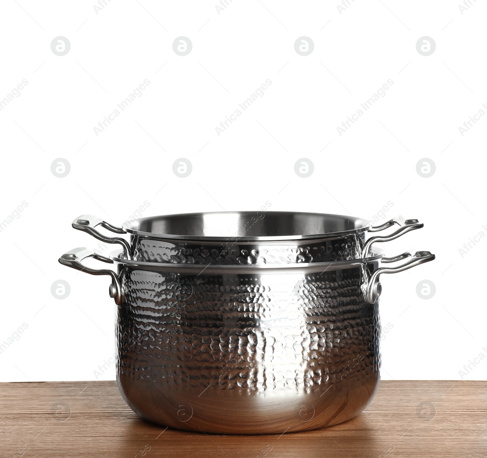 Photo of Stack of clean saucepans on table against white background