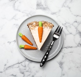 Plate with sweet carrot cake on white marble table, top view