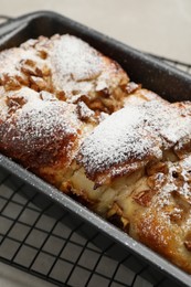 Photo of Delicious yeast dough cake in baking pan on table, closeup